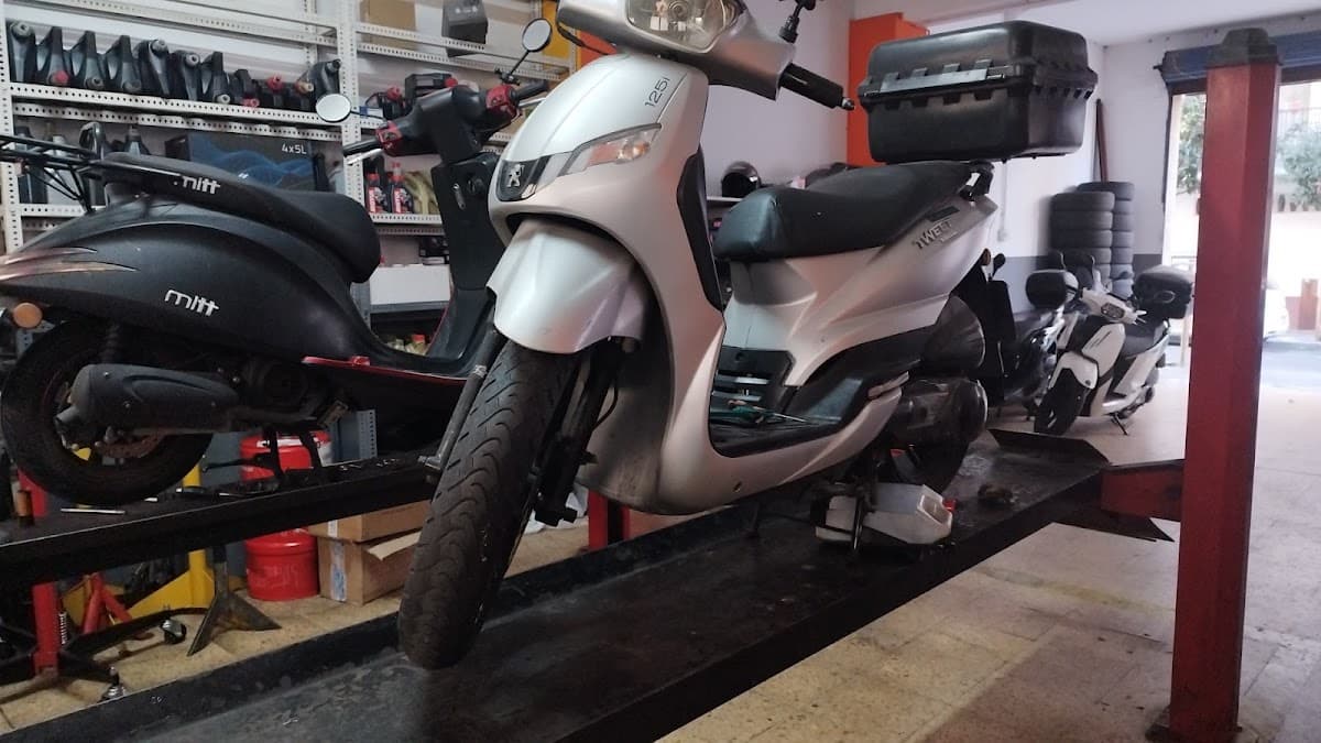 Motocicletas y vehículos en el elevador del taller YOCOMOTORS durante una reparación